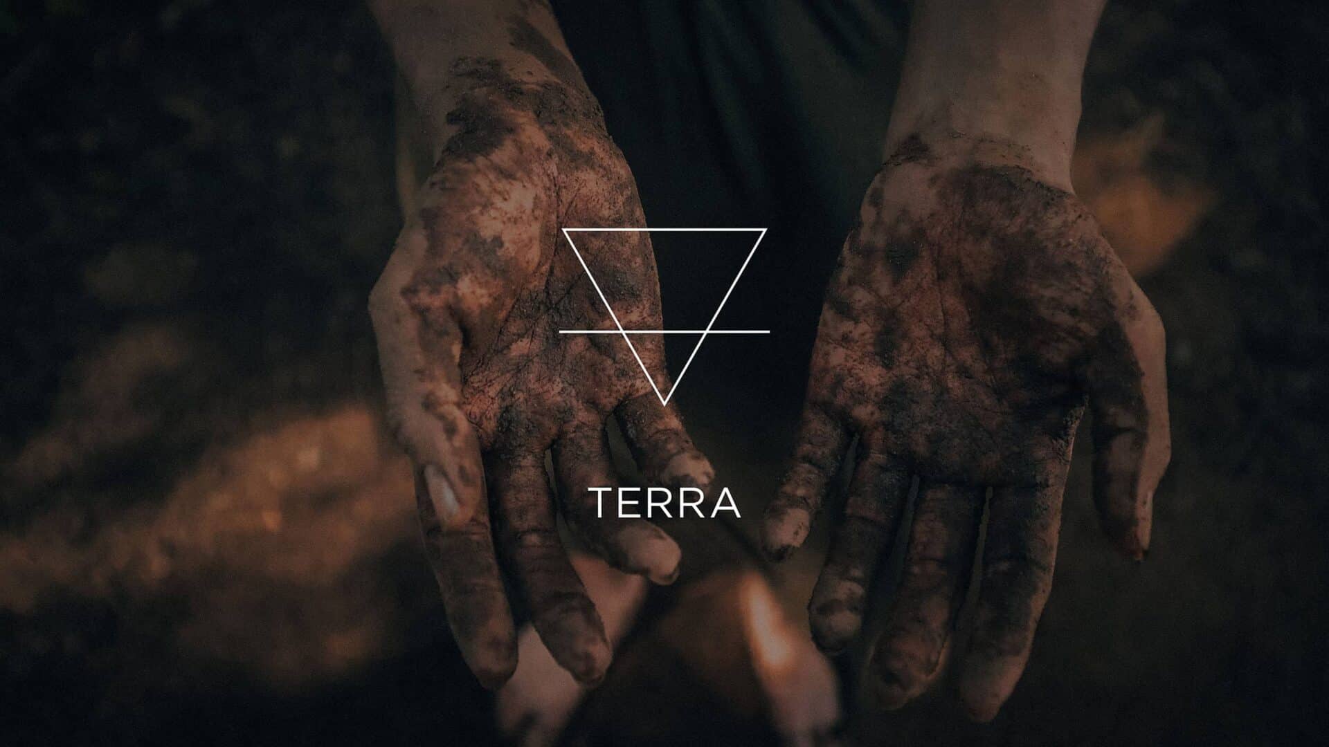 Mãos sujas de terra e o símbolo do elemento Terra